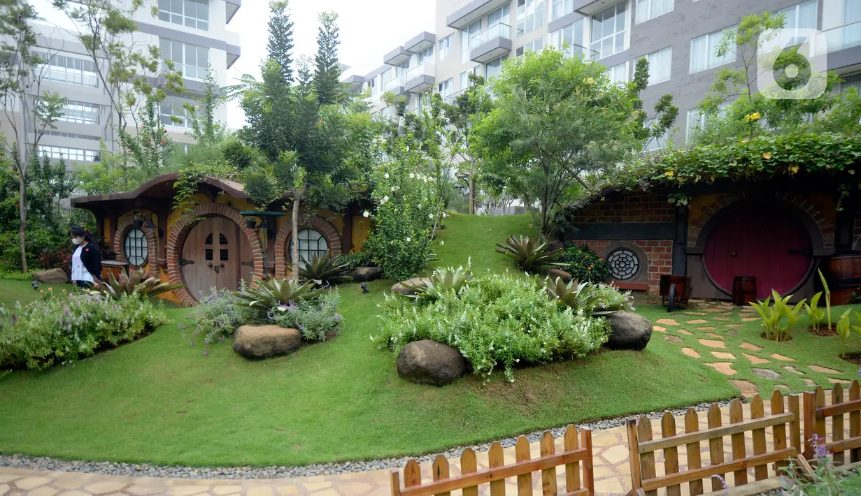 Seorang wanita berjalan di taman tematik bernuansa rumah hobbit di kawasan hunian vertikal di Serpong, Tangerang, Banten, Kamis (3/12/2020). Taman tematik tersebut bertujuan untuk mendukung relasi sosial antar warga serta menciptakan hunian sehat di tengah pandemi COVID-19. (merdeka.com/Dwi Narwoko)