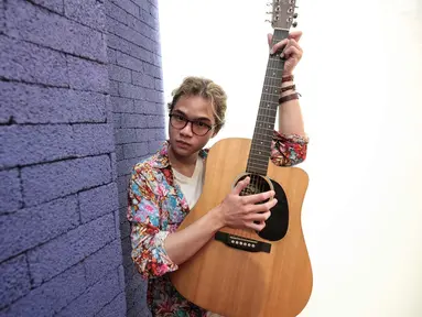 Putra ketiga Ahmad Dhani dan Maia Estianty, Abdul Qodir Jaelani alias Dul Jaelani berpose dengan gitarnya saat berkunjung ke kantor KLY, Gondangdia, Jakarta, Jumat (7/9). Remaja 18 tahun ini merilis singel "Taklukkan Dunia". (Liputan6.com/Faizal Fanani)