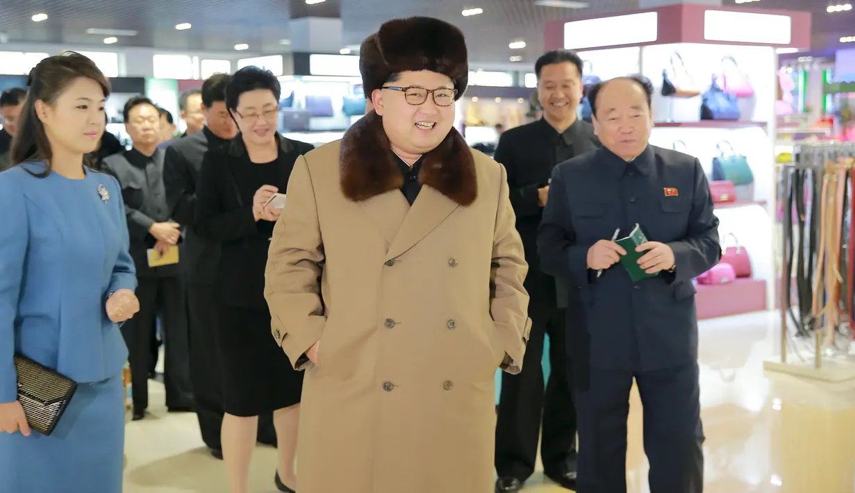 Pemimpin Korea Utara, Kim Jong-un berjalan sambil tersenyum mengunakan jaket dan topi tebal saat mengunjungi pusat perbelanjaan Mirae Shop yang baru dibangun di kompleks Mirae Shop di Korea Utara (28/3). (REUTERS/KCNA)