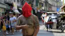 Seorang penganut Kristen Katolik Filipina berjalan sambil memakai topeng di kota Mandaluyong, Filipina, (24/3). Tradisi cambuk merupakan tradisi yang dilakukan oleh beberapa umat Katolik Filipina untuk menyambut hari Paskah. (REUTERS / Romeo Ranoco)