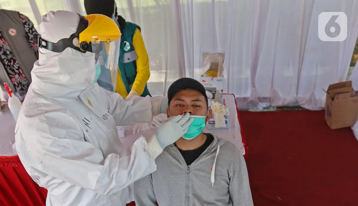 Warga yang hendak berlibur melakukan rapid test antigen yang disediakan oleh Dinas Kesehatan dan Petugas Gabungan dari unsur TNI, Polri dan Satpol PP Provinsi Jawa Barat di Rest Area KM 57, Tol Jakarta-Cikampek, Karawang, Jawa Barat, Kamis (24/12/2020). (Liputan6.com/Herman Zakharia)