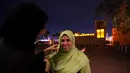Seorang relawan membantu wisatawan asing mengenakan jilbab saat belajar tentang puasa dan budaya Uni Emirat Arab (UEA) selama Ramadan di Masjid Jumeirah, Dubai, UEA, Jumat (17/5/2019). (REUTERS/Satish Kumar)