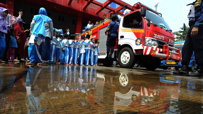 Sejumlah siswa TK di lingkungan Kabupaten Bogor menaiki mobil pemadam kebakaran saat berkunjung ke kantor Dinas Pemadam Kebakaran, Jalan Tegar beriman, Cibinong, Rabu (18/9/2019). Kegiatan belajar di luar kelas ini untuk mengenalkan profesi dan tugas pemadam kebakaran. (merdeka.com/Arie Basuki)