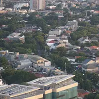 Lansekap pemukiman penduduk berlatar gedung bertingkat terlihat dari kawasan Senayan, Jakarta, Selasa (21/1/2020). Staf Khusus Kementerian PUPR Bidang Sumber Daya Air Firdaus Ali menjelaskan, ruang terbuka hijau di Jakarta baru 9,98% kurang dari syarat minimum 30%. (Liputan6.com/Immanuel Antonius)