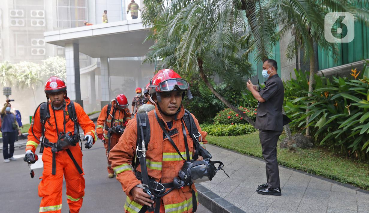 Petugas berlarian saat berusaha memadamkan kebakaran di Gedung Cyber 1, Jakarta, Kamis (2/12/2021). Sampai saat ini, penyebab kebakaran masih belum diketahui. (Liputan6.com/Herman Zakharia)