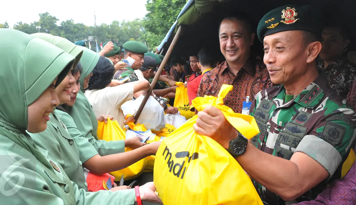 Pangkostrad Letjend TNI Mulyono (kanan) melayani pembeli dalam bazar murah menyambut Idul Fitri 1436 H, di Lapangan Kostrad, Jakarta, Selasa (7/7/2015). Bazar ini dikhususkan bagi para prajurit dan PNS di lingkungan Kostrad. (Liputan6.com/Herman Zakharia)