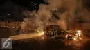 Petugas berusaha memadamkan api mobil yang terbakar di jalan layang Latuharhari, Jakarta, Kamis (18/9/2015). Diduga kebakaran akibat konsleting listrik yang terjadi dibagian depan kap mobil. (Liputan6.com/Faizal Fanani)