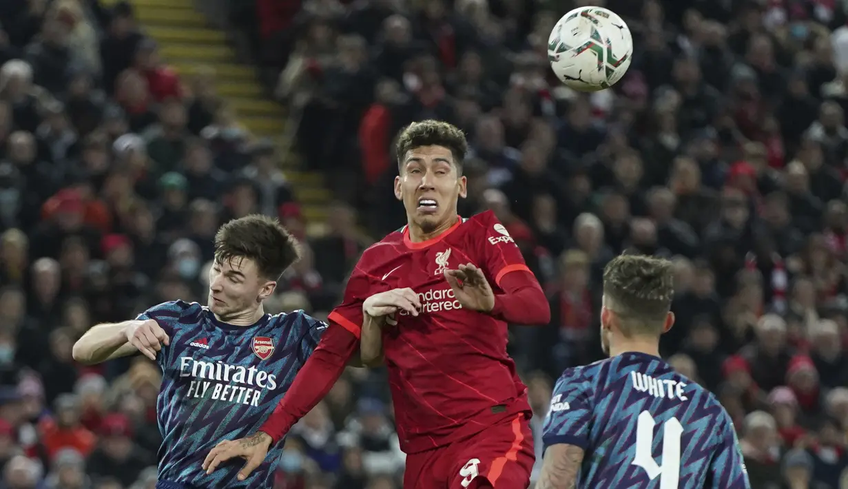 Penyerang Liverpool Roberto Firmino melakukan sundulan dengan bek Arsenal Kieran Tierney pada leg pertama semifinal Piala Liga Inggris di Stadion Anfield, Jumat (14/1/2022) dinihari WIB. Arsenal dipkasa bermain imbang tanpa gol oleh Liverpool. (AP Photo/Jon Super)