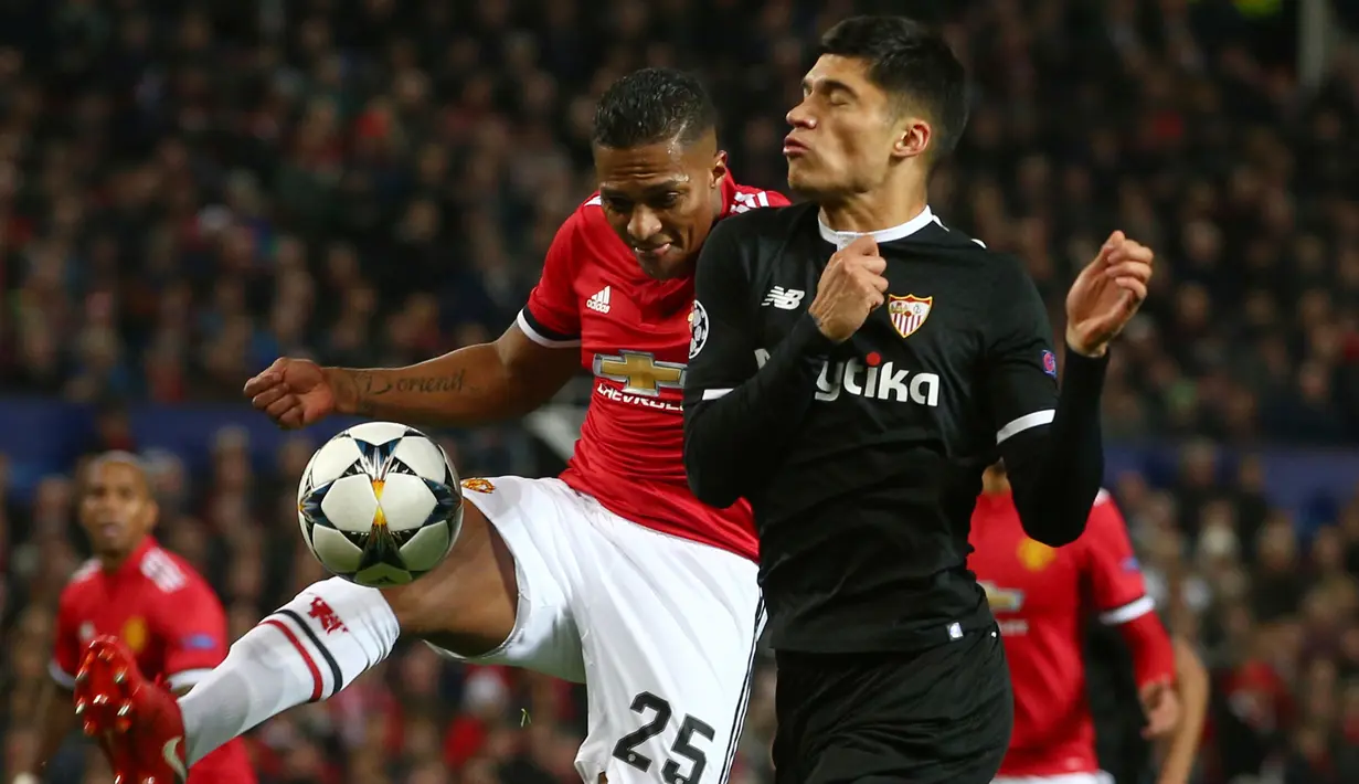 Pemain Sevilla, Joaquin Correa dan pemain Manchester United, Antonio Valencia berebut bola pada laga leg kedua 16 besar Liga Champions di Old Trafford, Selasa (13/3). Manchester United terhempas dari Liga Champions setelah kalah 1-2. (AP/Dave Thompson)