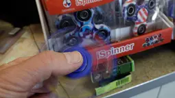 Fidget spinner dimainkan di sebuah yang bernama toko Funky Monkey Toys di Oxford, Mich (11/5). Secara umum, alat kecil seukuran jari ini dimainkan untuk mengusir rasa bosan atau cemas. (AP Photo / Carlos Osorio)