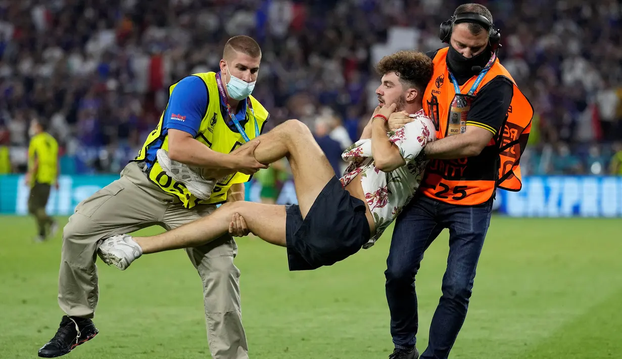 Petugas keamanan menangkap penyusup lapangan ketika pertandingan sepak bola Grup F UEFA EURO 2020 antara Portugal melawan Prancis yang berlangsung di Puskas Arena, Budapest pada 23 Juni 2021. (AFP/Pool/Darko Bandic)