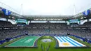 Para volunteer tetap mengangkat bendera tersebut selama seremoni tersebut berlangsung. Hal tersebut juga membuat bendera lawan, Uruguay juga sama perlakuannya untuk membuat visual yang seimbang. (AP Photo/Marta Lavandier)