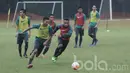 Pemain Timnas Indonesia U-22, Dendy Sulistyawan, berebut bola dengan Osvaldo Ardiles Haay. Porsi menu latlihan kali ini menitikberatkan pada membangun serangan. (Bola.com/M Iqbal Ichsan)