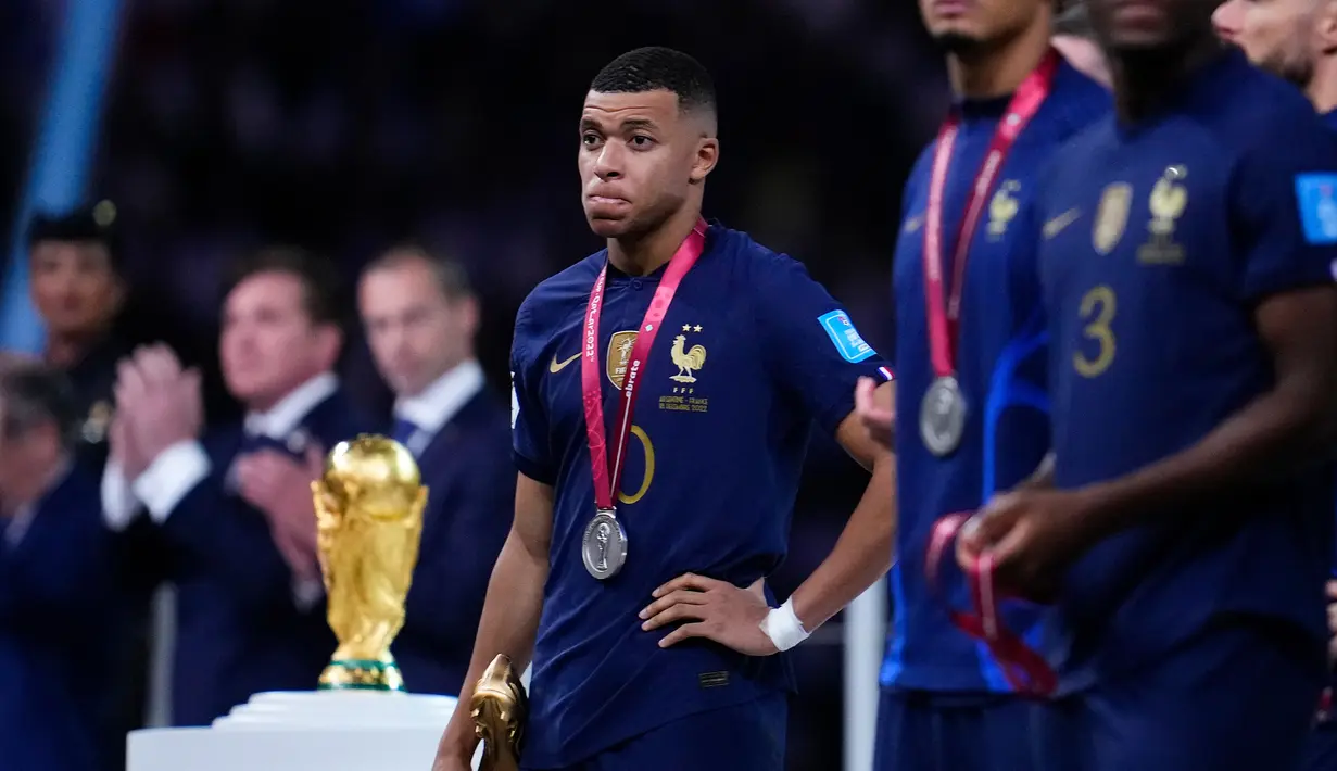 Ekspresi pemain Prancis Kylian Mbappe saat memegang penghargaan Sepatu Emas usai melawan Argentina pada pertandingan sepak bola final Piala Dunia 2022 di Stadion Lusail, Lusail, Qatar, 18 Desember 2022. Argentina menang 4-2 dalam adu penalti melawan Prancis setelah pertandingan berakhir imbang 3 -3. (AP Photo/Natacha Pisarenko)