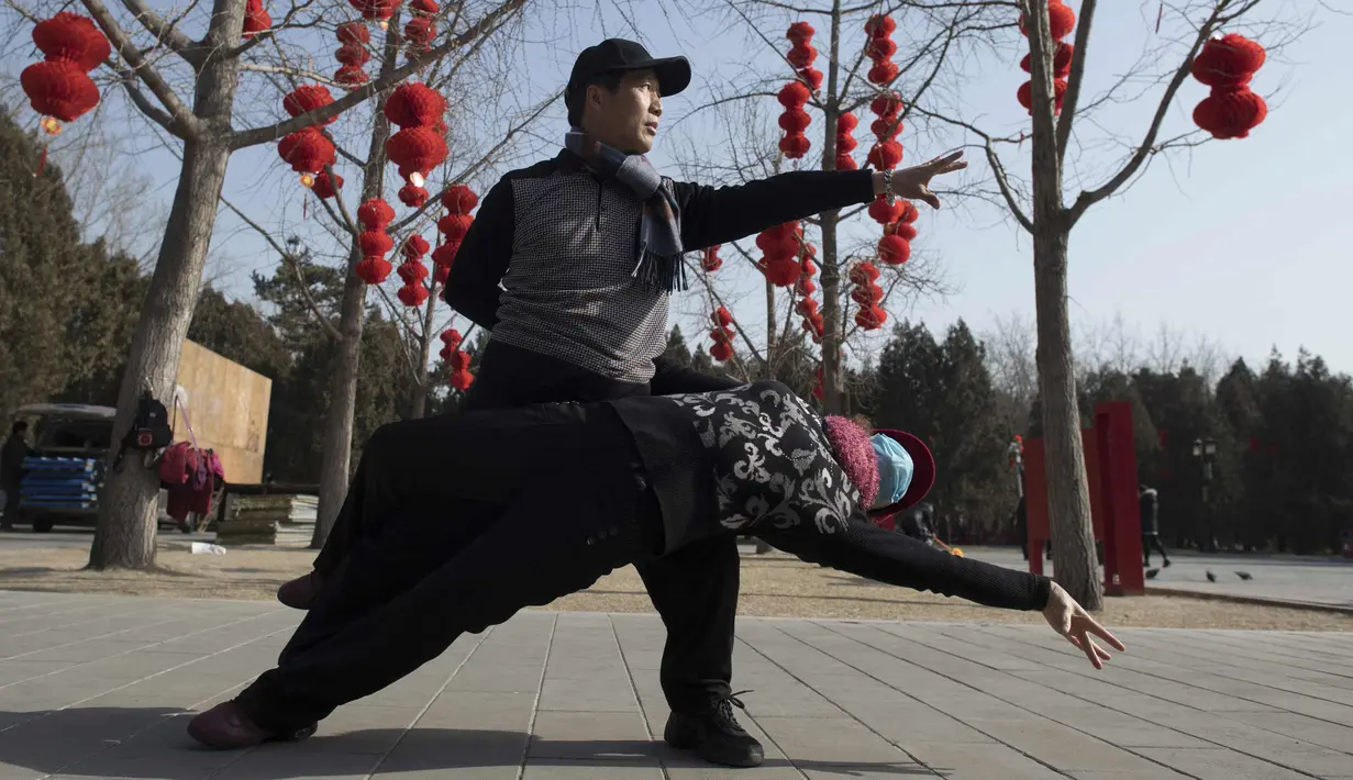 Seorang pria dan wanita berdansa di Ditan Park di Beijing (1/2). Tahun Baru Imlek jatuh pada 16 Februari tahun ini, dengan perayaan yang berlangsung selama seminggu di China. (AFP Photo/Nicolas Asfouri)