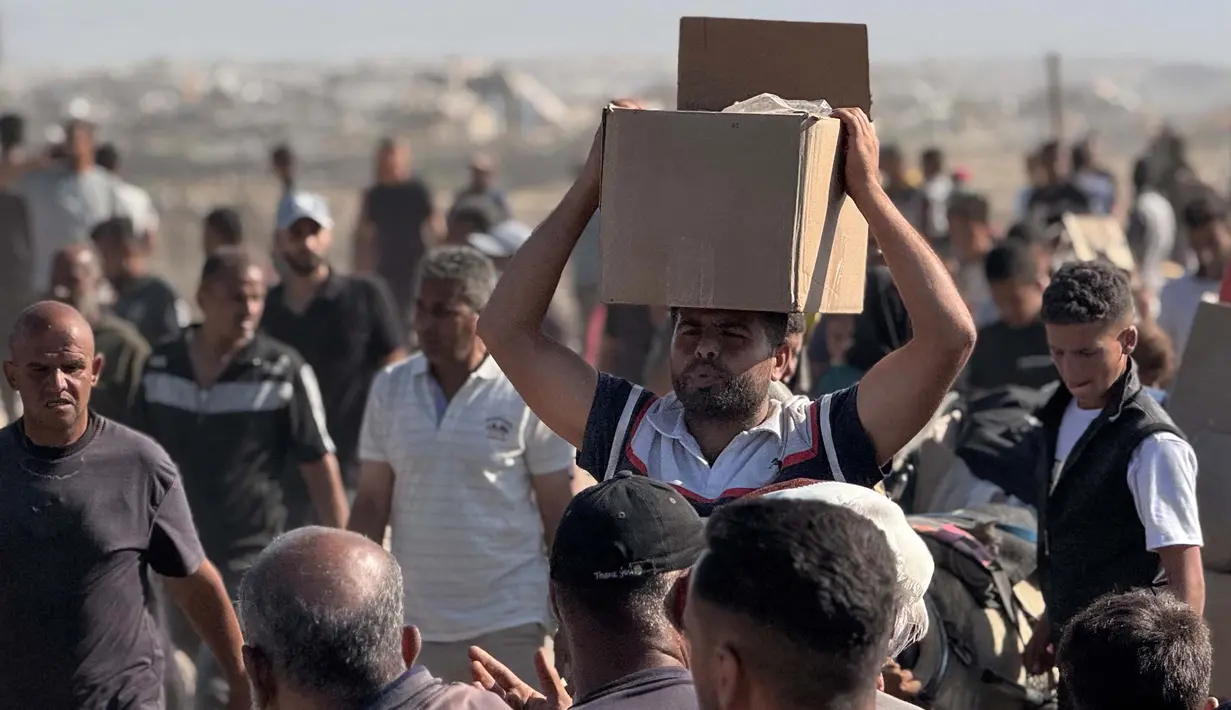 Kericuhan terjadi ketika warga Palestina menyerbu pusat distribusi makanan dengan menerobos pagar pembatas. Pasukan Israel di dekatnya melepaskan tembakan peringatan untuk menghentikan penyerbuan. Situasi inilah yang kemudian memicu kepanikan dan kekacauan. (Foto oleh AFP)