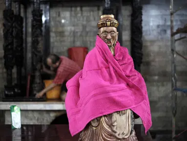 Proses pengeringan patung dewa-dewi di Vihara Amurva Bhumi, Jakarta, Kamis (8/2). Bersih-bersih patung dewa-dewi dan vihara dilakukan agar ibadah dan perayaan Imlek berjalan khusyuk. (Liputan6.com/Arya Manggala)