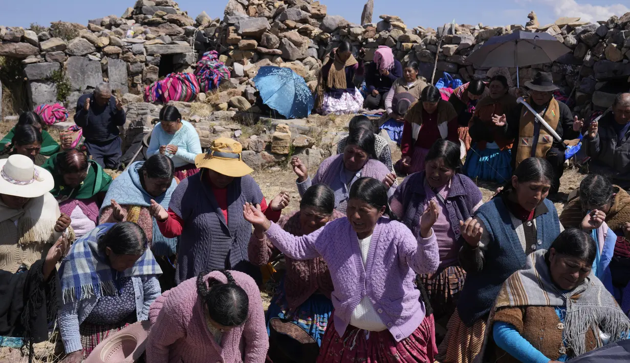 Wanita suku Aymara berdoa pada hari puasa sebagai ritual meminta hujan di Gunung Suci Inca Pucara, Chiquipata, Bolivia, Rabu (16/11/2022). Penduduk dataran tinggi La Paz mengatakan rendahnya curah hujan yang terjadi sejak September membuat mereka tidak bisa menanam kentang, buncis, dan kacang polong. (AP Photo/Juan Karita)