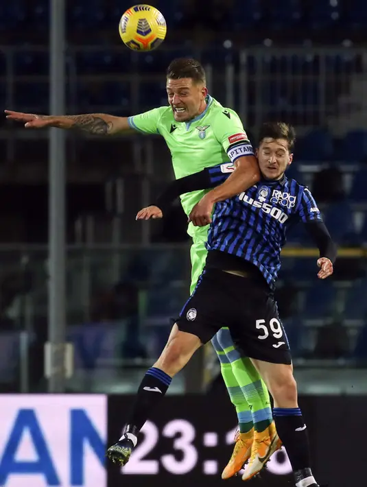 Pemain Atalanta Aleksej Miranchuk (kanan) berebut bola dengan pemain Lazio Francesco Acerbi pada pertandingan Coppa Italia di Stadion Gewiss, Bergamo, Italia, Rabu (27/1/2021). Atalanta melaju ke semifinal Coppa Italia usai menaklukkan Lazio 3-2. (Stefano Nicoli/LaPresse via AP)