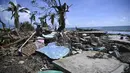 Sepasang suami istri berjalan di tengah puing-puing rumah yang rusak akibat Badai Melissa di desa Boca de Dos Rios, provinsi Santiago de Cuba, Kuba pada Kamis 30 Oktober 2025. Badai Melissa bergerak menuju Bermuda setelah menghancurkan Karibia dan menewaskan sedikitnya 20 orang di Haiti, serta menghancurkan sebagian Jamaika dan Kuba. (YAMIL LAGE/AFP)