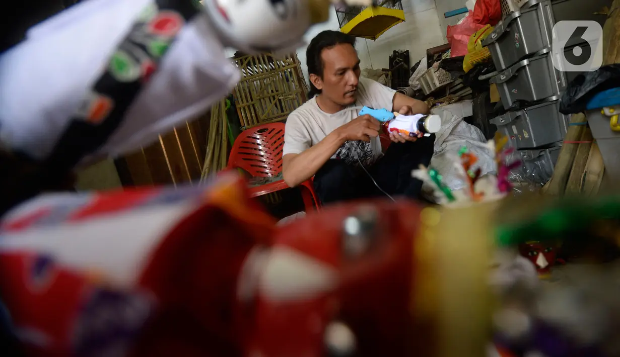 Pengrajin  menyelesaikan ondel-ondel hiasan yang terbuat dari limbah plastik botol di Kampung Sawah Lama, Ciputat, Tangerang Selatan, banten, Jumat (4/9/2020). Harga satu perpasang dijual dengan harga Rp 35 ribu, pada saat pandemi ini pemesanan menurut hingga 40 persen. (merdeka.com/Dwi Narwoko)