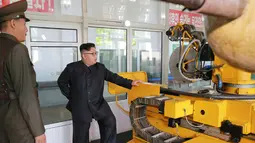 Pemimpin Korea Utara, Kim Jong-Un saat melakukan kunjungan ke institut material kimia di Akademi Ilmu Pertahanan pada tanggal 23 Agustus 2017. Kim Jong-Un juga ditunjukkan mesin roket dengan bahan bakar padat.  (AFP Photo/Kcna Via Kns/Str)
