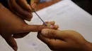 Sebelum menggunakan hak politiknya, jari para pemilih di India diberikan tanda tinta oleh petugas pemilihan setempat. (AFP PHOTO/Arindam DEY)