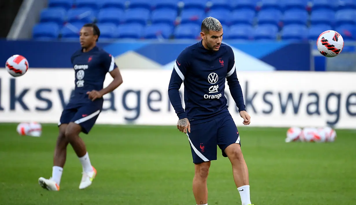 Bek Prancis Jules Kounde (kiri) dan Theo Hernandez menghadiri sesi latihan di Stadion Groupama, dekat Lyon, Senin (6/9/2021). Prancis akan berhadapan dengan Finlandia dalam lanjutan Kualifikasi Piala Dunia 2022 zona Eropa Grup D, Rabu (8/9) dinihari. (FRANCK FIFE / AFP)