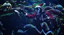 Seorang penyelam berpakaian seperti Sinterklas memberi makan ikan di akuarium Sea Life Bangkok Ocean World di Bangkok, Thailand, Rabu (8/12/2021). Ikan-ikan menyantap makanan dari tangan Sinterklas yang berinteraksi dengan pengunjung dan berpose dari balik kaca akuarium (Lillian SUWANRUMPHA/AFP)