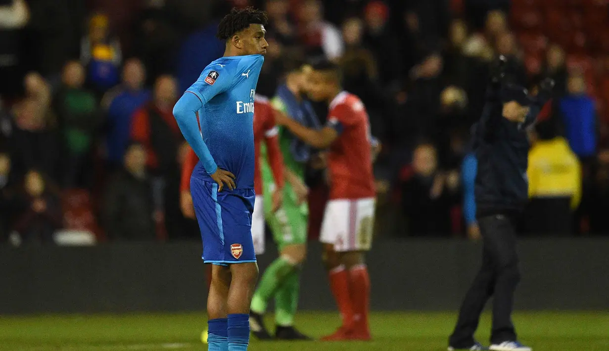 Penyerang Arsenal,  Alex Iwobi mengigit kaosnya usai pertandingan melawan Nottingham Forest di pertandingan babak ketiga Piala FA di City Ground, Nottingham, Inggris (7/1). Arsenal kalah 4-2 atas Nottingham Forest. (AFP Photo/Oli Scarff)