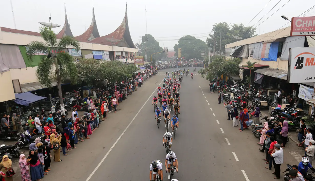 Para pebalap sedang melewati sebuah pasar di kota Payakumbuh dalam Etape 5 Tour de Singkarak 2015, Rabu (7/10/2015). (Bola.com/Arief Bagus)