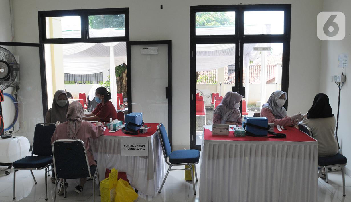 Paramedis memberikan vaksin booster saat pelaksanaan vaksinasi serentak Pemkot Depok di Kantor Kecamatan Cinere, Depok, Senin (18/4/20222). Gebyar vaksinasi booster secara massal ini bertujuan memberikan kemudahan bagi warga sebelum melakukan perjalanan mudik lebaran 2022. (merdeka.com/Arie Basuki)