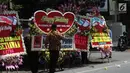 Warga melintas di depan karangan bunga untuk pernikahan Kahiyang-Bobby di sepanjang jalan menuju Gedung Graha Saba di Solo, Senin (6/11). Pernikahan putri Presiden Joko Widodo tersebut akan berlangsung pada Rabu (8/11) esok. (Liputan6.com/Angga Yuniar)