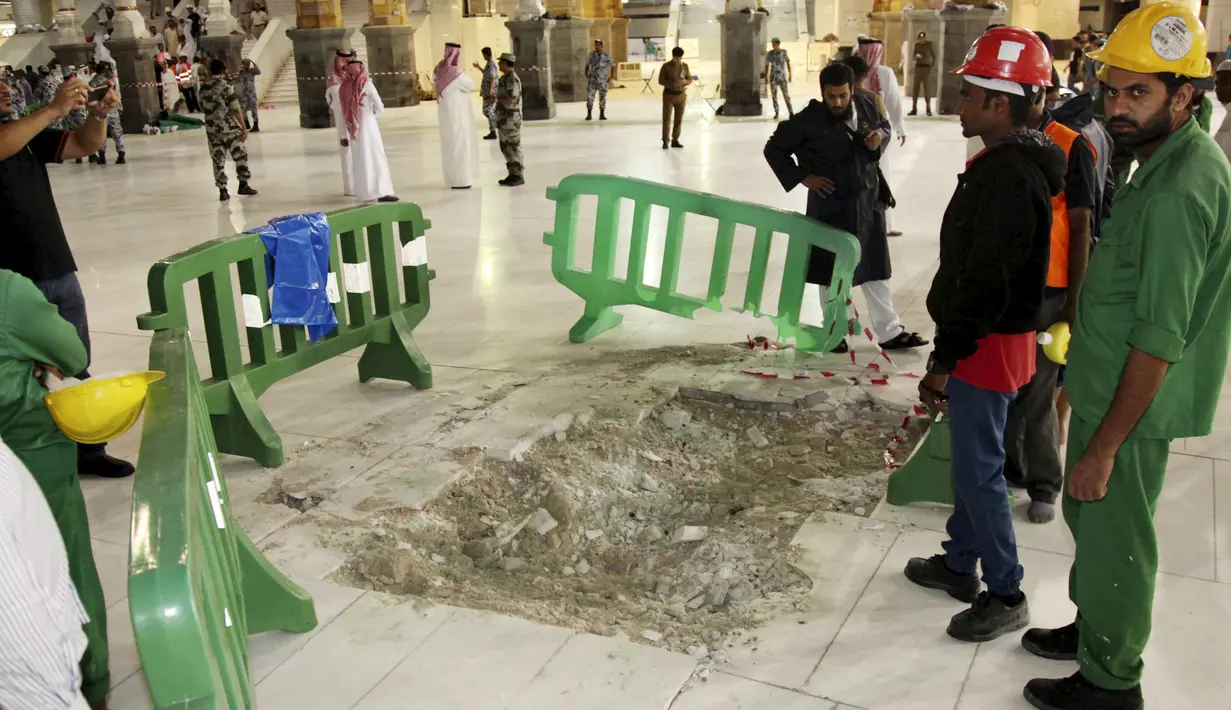 Petugas berdiri di dekat kerusakan yang disebabkan jatuhnya alat berat proyek (crane) di Masjidil Haram, Mekkah, Jumat (11/9/2015). Sebanyak 107 orang dilaporkan tewas, termasuk warga negara Indonesia. (REUTERS/Stringer)