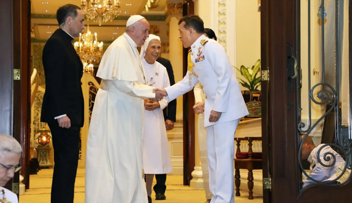 Paus Fransiskus ditemani oleh Suster Anna Rosa Sivori berjabat tangan dengan Raja Thailand Maha Vajiralongkorn di Amporn Throne Hall Dusit Palace di Bangkok (22/11/2019). (Handout/Thai Royal Household Bureau/AFP)