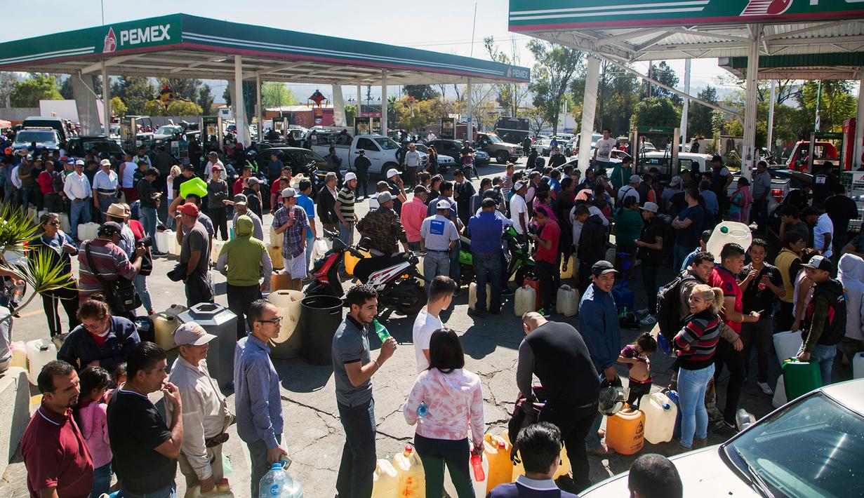 Antrean puluhan warga di tengah kelangkaan BBM di sebuah SPBU di Morelia, Meksiko, Selasa (8/1). Kelangkaan BBM tersebut akibat terjadinya pencurian dari jaringan pipa dan dari internal Pemex, perusahaan minyak milik negara. (ENRIQUE CASTRO/AFP)