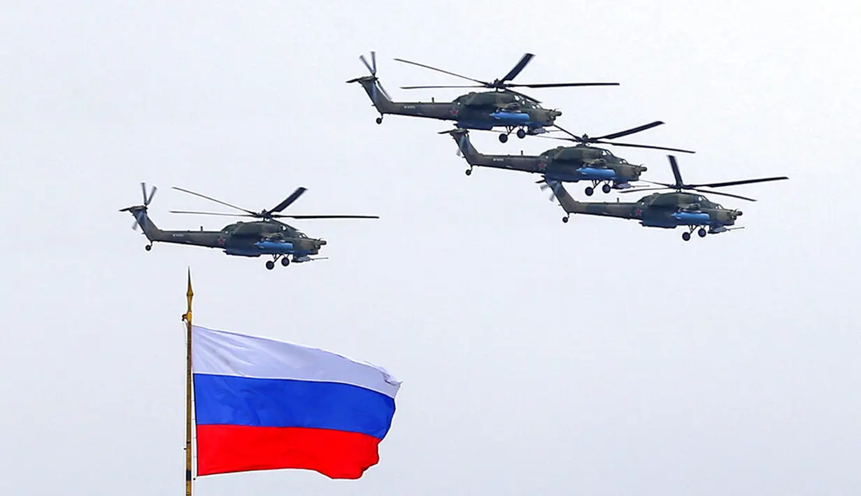 Helikopter militer Rusia mengibarkan bendera nasional Rusia saat parade militer Hari Kemenangan di Moskow, Rusia, Minggu (9/5/2021). Parade militer ini untuk memperingati 76 tahun berakhirnya Perang Dunia II di Eropa. (AP Photo/Alexander Zemlianichenko Jr.)