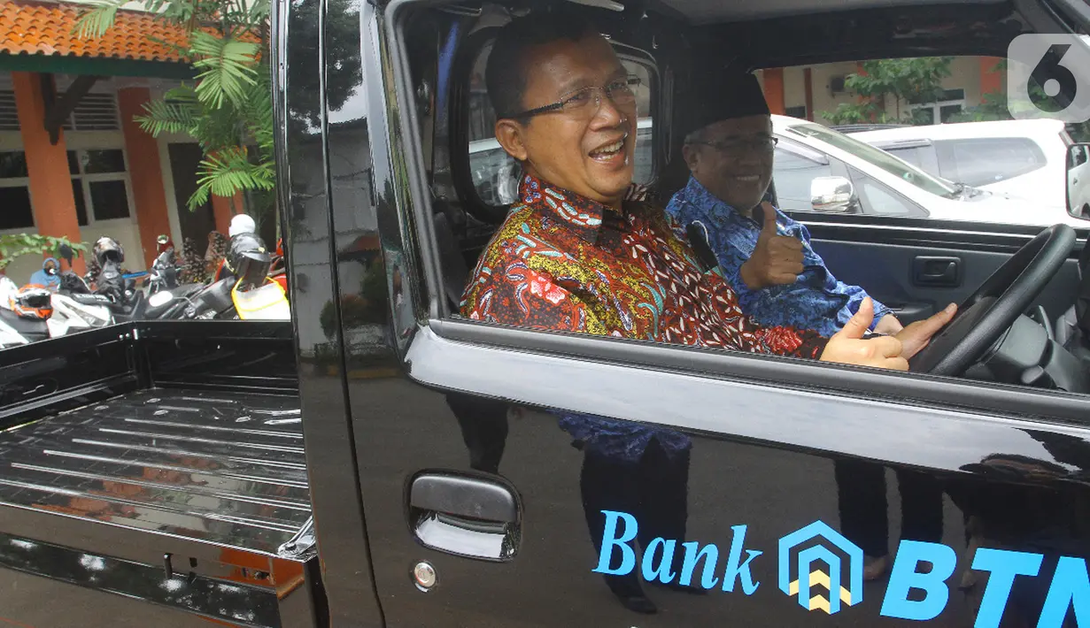 Direktur Utama Bank BTN Haru Koesmahargyo menaiki mobil sarana kebersihan usai serah terima bantuan tanggung jawab sosial dan lingkungan (TJSL) berupa kendaraan sarana kebersihan di Kampus UIN Sultan Maulana Hasanuddin, Serang, Banten, Kamis (17/3/2022). (Liputan6.com/HO/BTN)