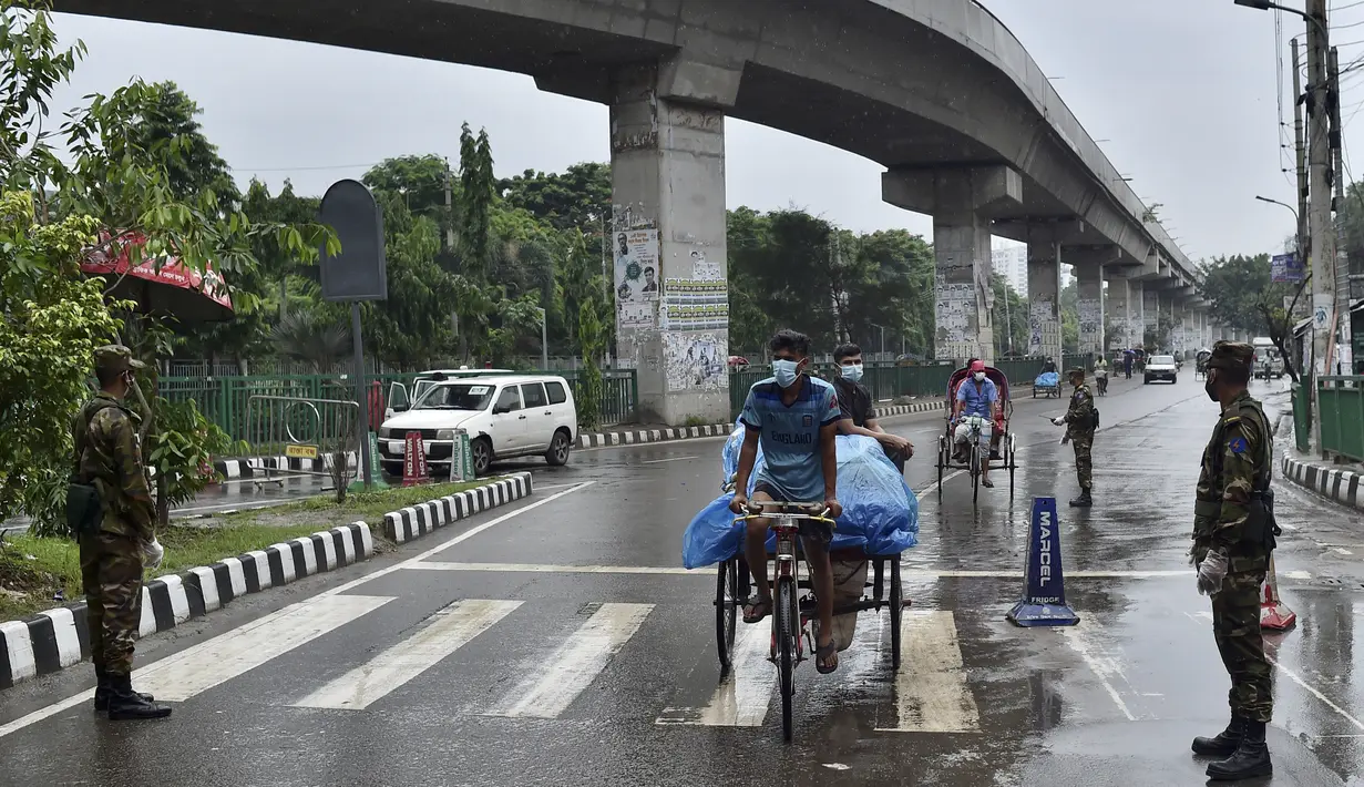 Tentara Bangladesh menjaga pos pemeriksaan sepanjang jalan di Dhaka, Bangladesh, Kamis (1/7/2021). Mulai 1 Juli diberlakukan lockdown, Tentara dan Polisi Bangladesh diperintahkan untuk menghentikan orang-orang yang meninggalkan rumah mereka kecuali untuk keadaan darurat. (AFP/Munir Uz zaman)