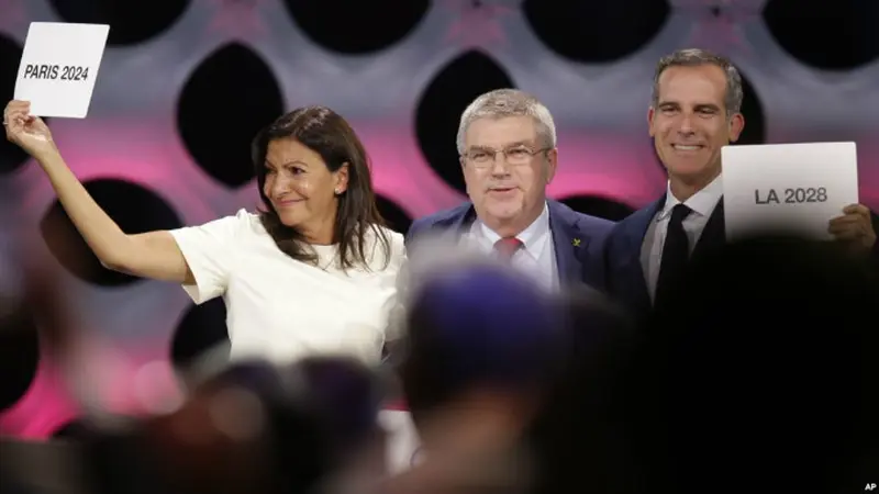 Ketua Komite Olimpiade Internasional (IOC) Thomas Bach (tengah) berpose bersama Walikota Paris Anne Hidalgo (kiri) dan Walikota Los Angeles Eric Garrett di markasa IOC di Lima, Peru (AP)