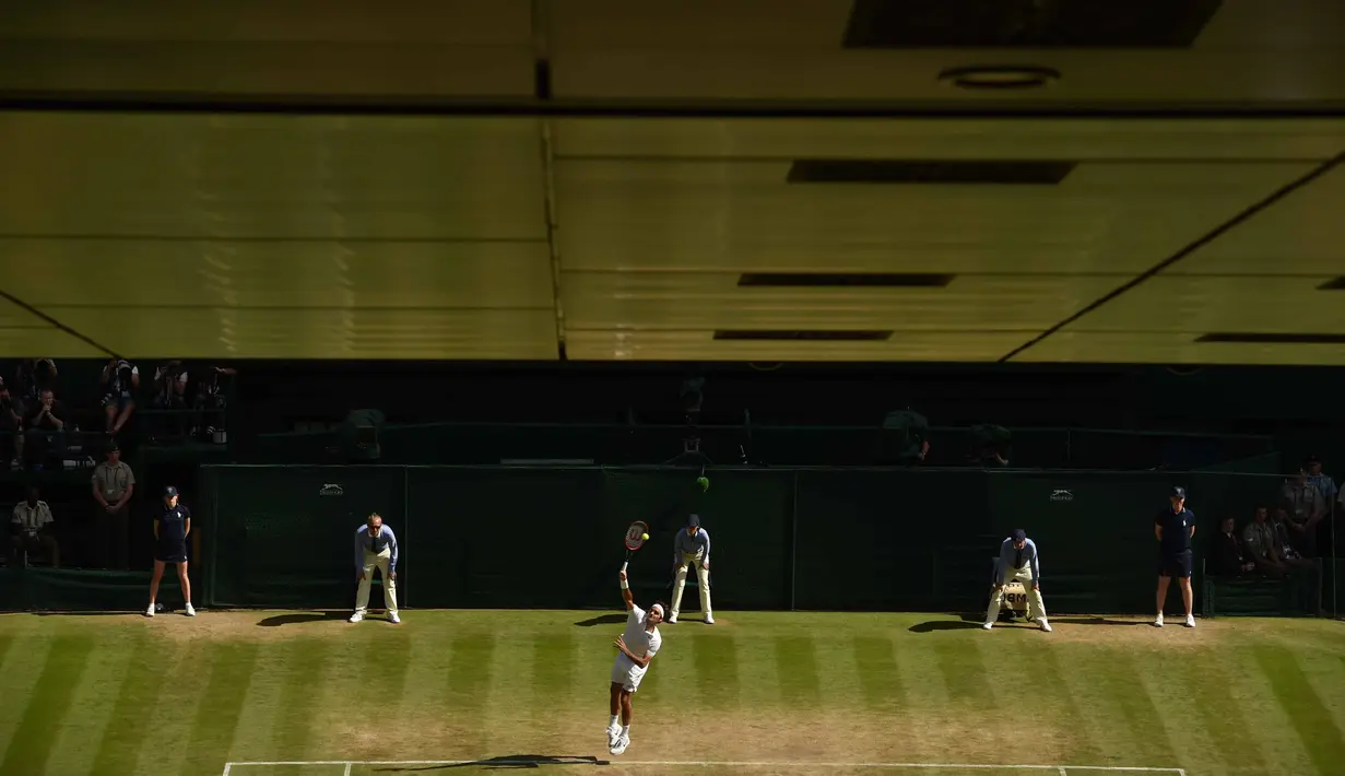 Aksi Roger Federer  saat melakukan servis melawan petenis Kroasia, Marin Cilic pada babak perempat final Tenis Wimbledon Championships 2016 di The All England Lawn Tennis Club,  Wimbledon, (6/7/2016). (AFP/Glyn Kirk)