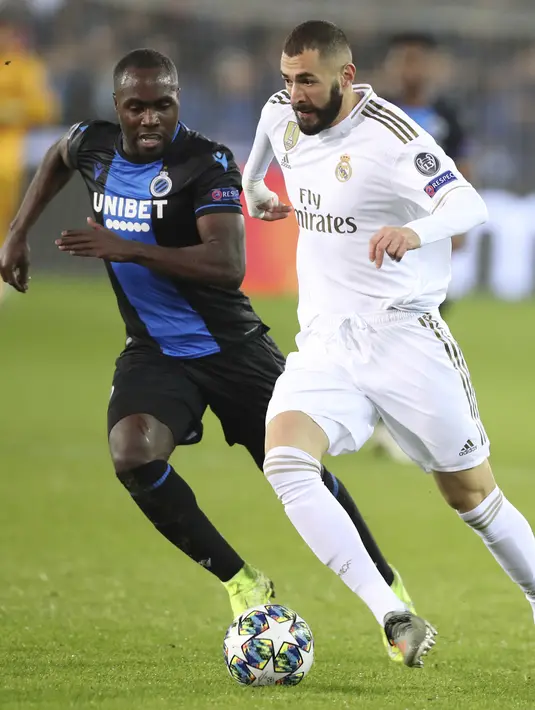 Penyerang Real Madrid, Karim Benzema menggiring bola dari kawalan pemain Club Brugge, Eder Balanta pada pertandingan Grup A Liga Champions di stadion Jan Breydel di Bruges, Belgia (11/12/2019). Real Madrid menang 3-1 atas Club Brugge. (AP Photo/Francisco Seco)