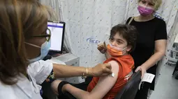 Petugas kesehatan menyuntikkan vaksin COVID-19 Pfizer-BioNTech kepada remaja Israel di kota Rishon LeZion, Minggu (6/6/2021). Israel mulai memvaksinasi anak-anak dari usia 12 hingga 15 pada hari Minggu. (AP Photo/Sebastian Scheiner)