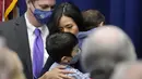 Michelle Wu mencium putranya Blaise, sambil menggendong sang anak Cass, setelah Wali Kota Boston di Balai Kota Boston, Selasa (16/11/2021). Michelle Wu juga merupakan orang kulit berwarna pertama sepanjang sejarah, yang berhasil terpilih dalam Pemilihan Wali Kota Boston. (AP Photo/Charles Krupa)