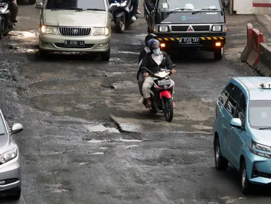 Sejumlah pengendara melintasi sebagian Jalan Rasuna Said, Kuningan yang rusak, Jakarta, Selasa (22/2/2022). Kerusakan jalan tersebut bisa membahayakan keselamatan pengendara dan menghambat arus lalu lintas. (Liputan6.com/Helmi Fithriansyah)