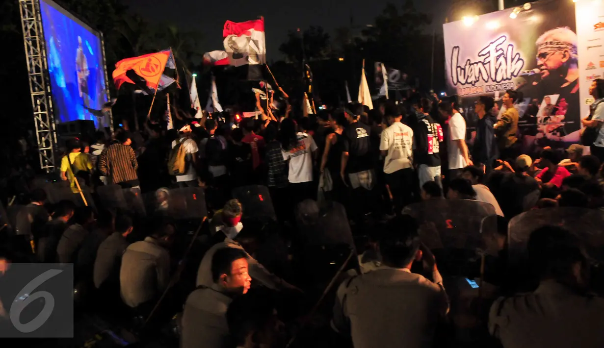 Sejumlah aparat ikut menikmati pertunjukkan Iwan Fals melalui layar besar Senayan, Jakarta, Sabtu (21/11/2015). Selama acara berlangsung, kondisi di luar gedung pertunjukkan, aman dan tertib (Liputan6.com/Faisal R Syam)