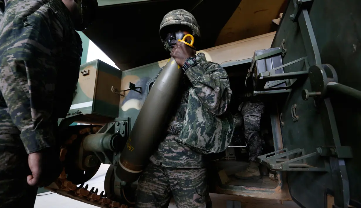 Tentara marinir mengeluarkan mortir selama latihan di Pulau Yeonpyeong, Korsel (1/11). Zona larangan terbang dan larangan latihan militer di dekat perbatasan yang dijaga ketat antara Korut dan Korsel mulai berlaku hari ini. (AP Photo/Jeon Heon-kyun)