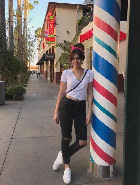 Anak zaman now banget kan? Ripped jeans hitam yang dipadukan dengan crop top putih, rambut bergaya bun hair dan bandana merah. Ini lah gaya kekinian Vanesha dan sangat cocok untuknya. (Instagram/vaneshaass)