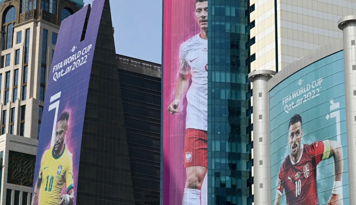 <p>Gambar besar penyerang Brasil Neymar Jr (kiri), Robert Lewandowski dari Polandia (tengah), dan kapten Serbia Dusan Tadic menghiasi gedung-gedung jelang Piala Dunia 2022 di Doha, Qatar, Minggu (6/11/2022). Piala Dunia 2022 akan dimulai pada 20 November 2022 hingga 18 Desember dengan menampilkan pertandingan pembuka antara tuan rumah Qatar vs Ekuador pada 20 November 2022. (Gabriel BOUYS/AFP)</p>