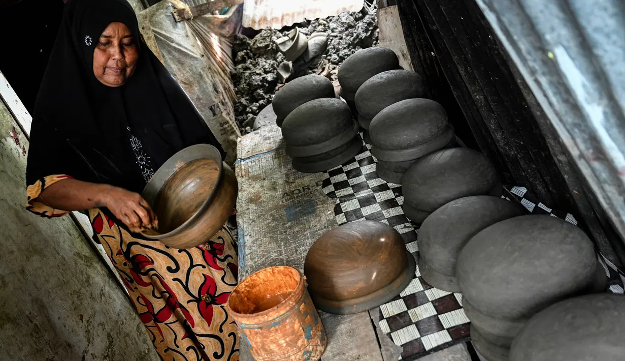 Seorang pembuat tembikar membuat pot tanah liat menggunakan tangan dalam bengkel rumah di Banda Aceh, Aceh, Rabu (4/8/2021). (CHAIDEER MAHYUDDIN/AFP)